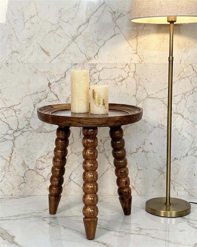 Wooden table with candles, next to floor lamp.