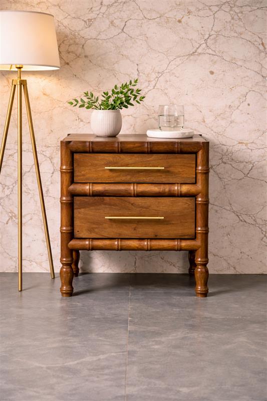 Wooden nightstand with plant beside lamp